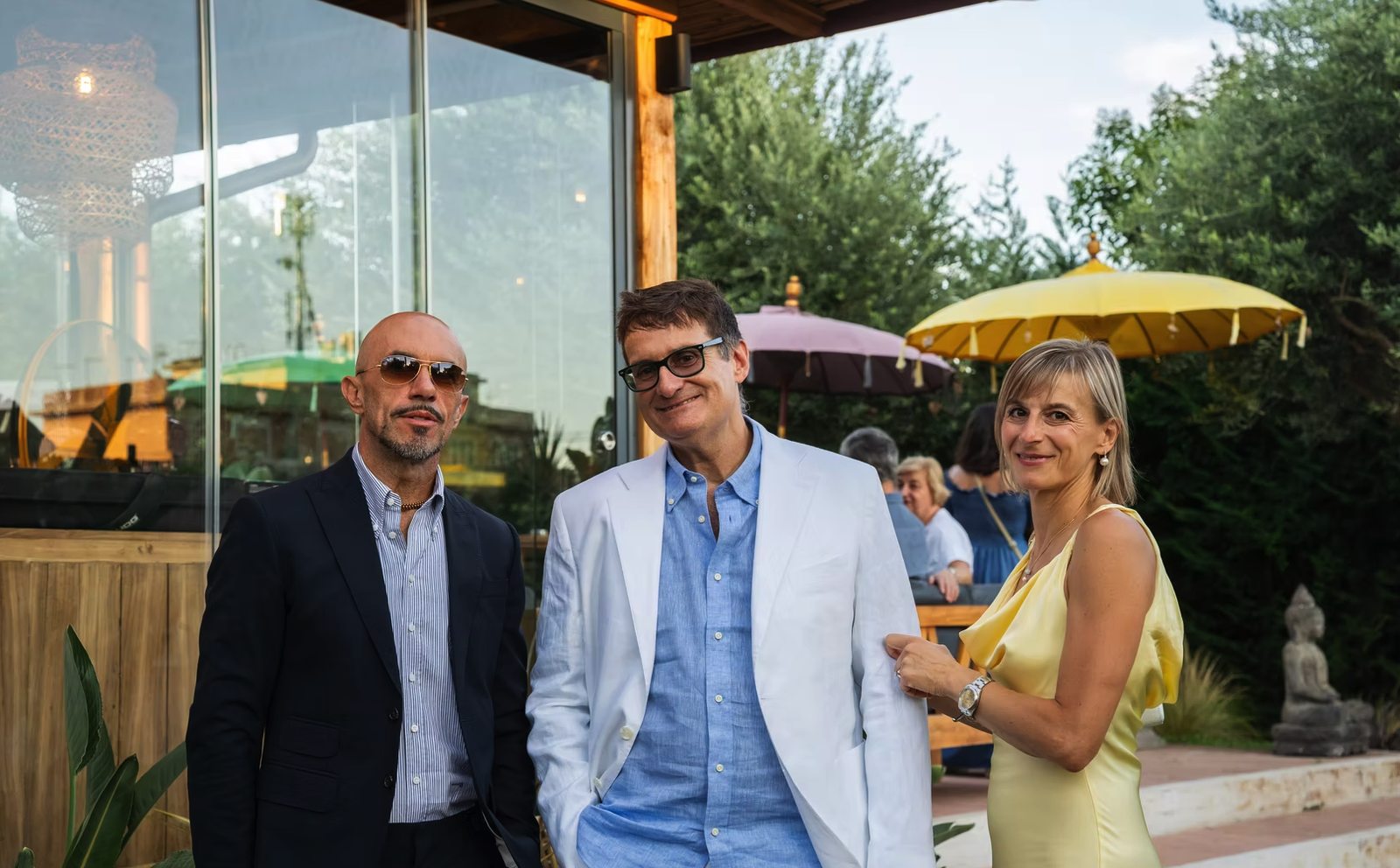 Ospiti in abito elegante all'ingresso, con gli ombrelloni balinesi alle spalle